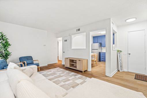 A living room with a white couch and a blue chair.