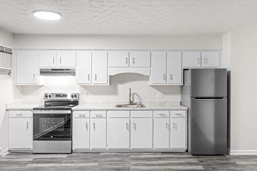 A modern kitchen with white cabinets and appliances.