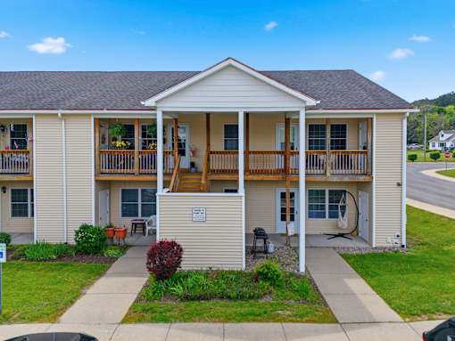 A two-story apartment building with a balcony on the second floor.