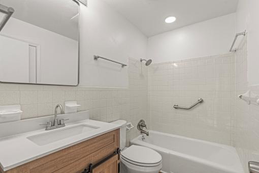 A white bathroom with a toilet, sink, and bathtub.