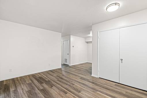 A room with a white wall and a wooden floor.