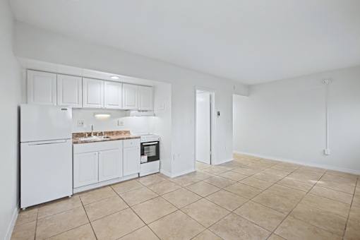 A kitchen with white appliances and cabinets.