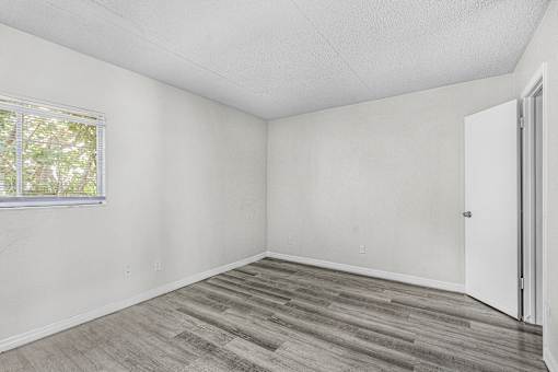 A room with a wooden floor and a window.