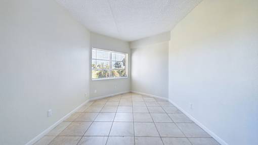 Empty room with tiled floor and a window.