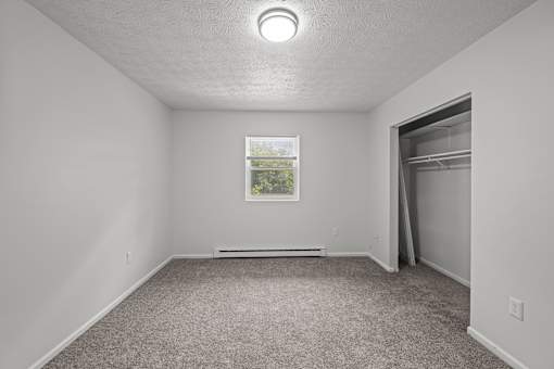 A room with a window and a picture on the wall.