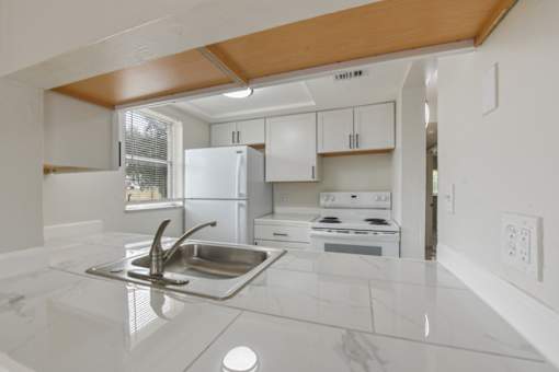 A kitchen with a sink and a stove top oven.