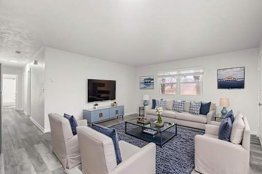 A living room with a grey carpet and a white sofa.