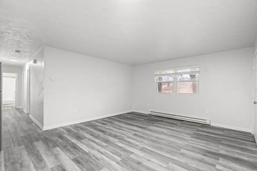 A room with a window and wooden flooring.