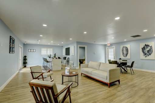 A living room with a couch, chairs, and a coffee table.