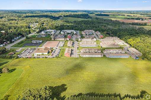 A large green field with a building complex in the middle.