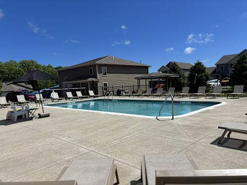 A pool with a slide and a building behind it.