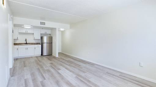 A kitchen with white cabinets and a stainless steel refrigerator.