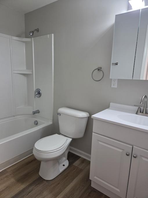 A white toilet sits next to a sink in a small bathroom.