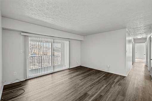 A room with wooden flooring and white walls.