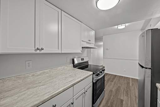 A kitchen with white cabinets and a black stove top oven.