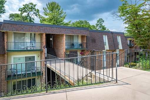 A brick building with a balcony and a metal railing.