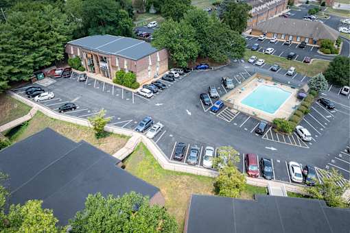 A parking lot with a pool and a building in the background.