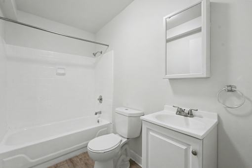 A white bathroom with a toilet, sink, and bathtub.