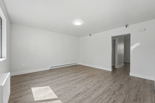 A room with a white wall and a wooden floor.