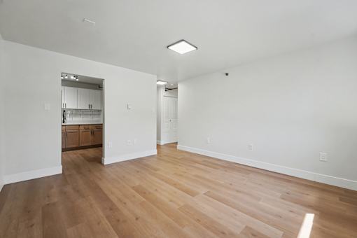 A room with wooden floors and a mirror on the wall.