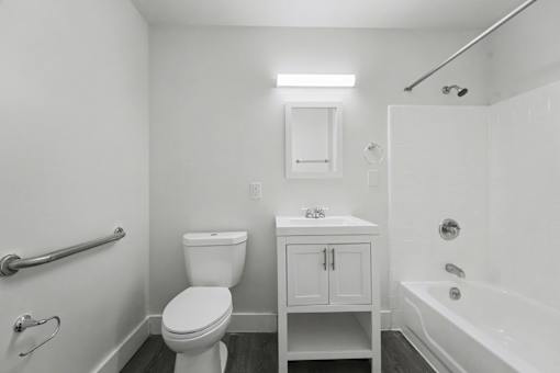 A white bathroom with a toilet, sink, and bathtub.