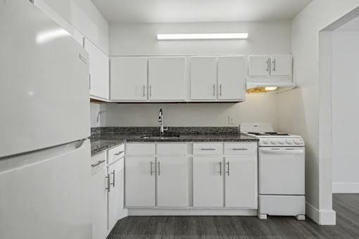 A kitchen with white cabinets and appliances.