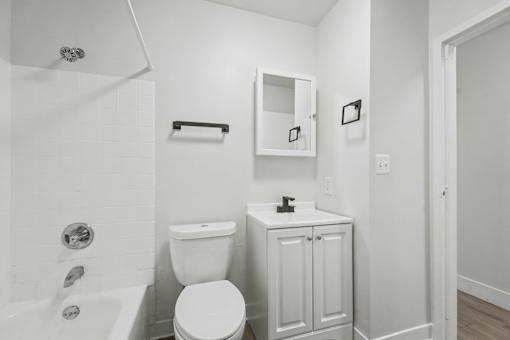 A white bathroom with a toilet, sink, and bathtub.
