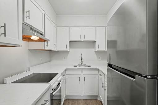 A kitchen with white cabinets and appliances.