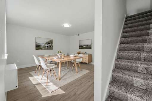 A dining room with a wooden table and chairs.