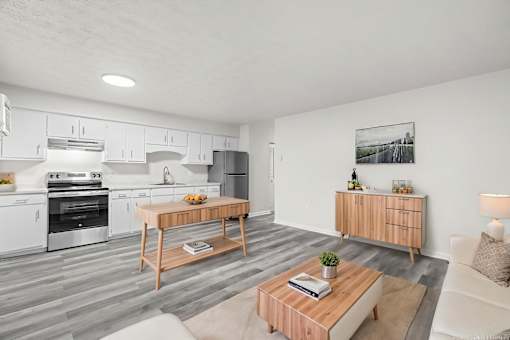 A modern kitchen with a wooden coffee table in the middle.