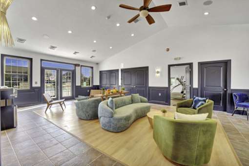 A living room with a green couch and a ceiling fan.