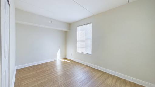 Empty room with wooden floor and white walls.