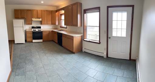 A kitchen with wooden cabinets and a white refrigerator.
