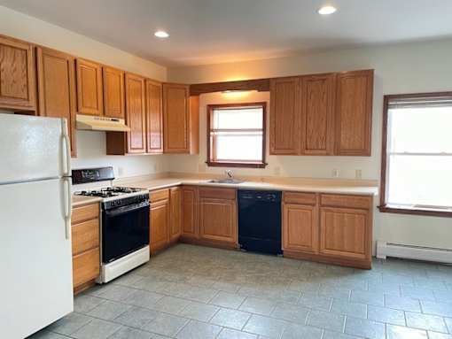 A kitchen with wooden cabinets and a white refrigerator.