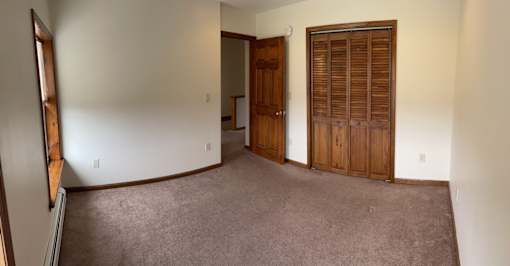 A room with a brown carpet and a brown door.