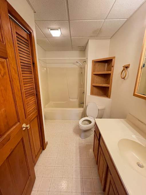 A bathroom with a toilet, sink, and shower.