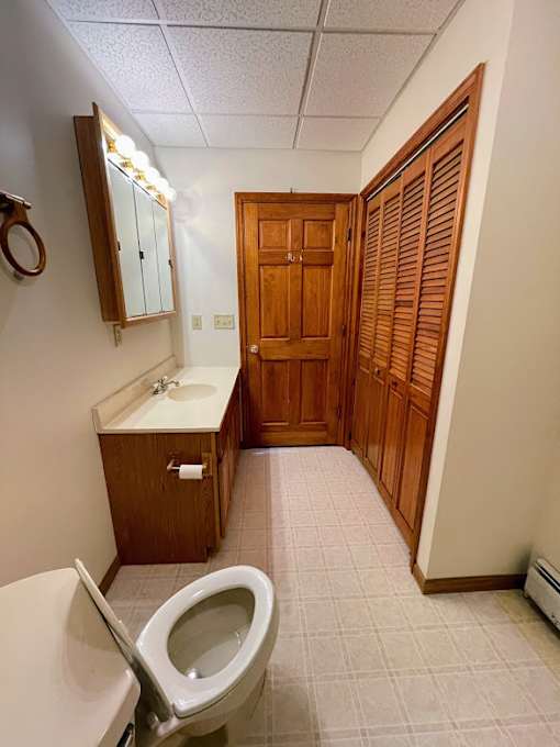 A bathroom with a toilet, sink, and medicine cabinet.