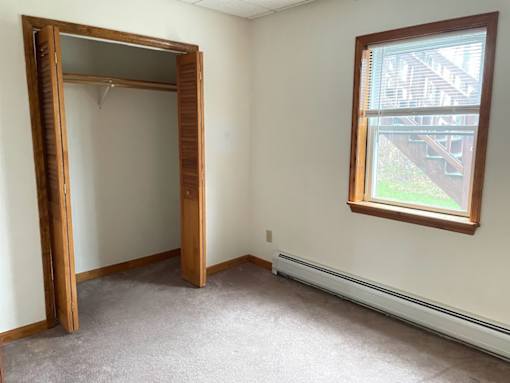 A room with a large mirror and a window.