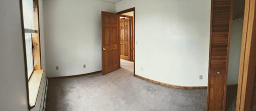 A room with a wooden door and a window.