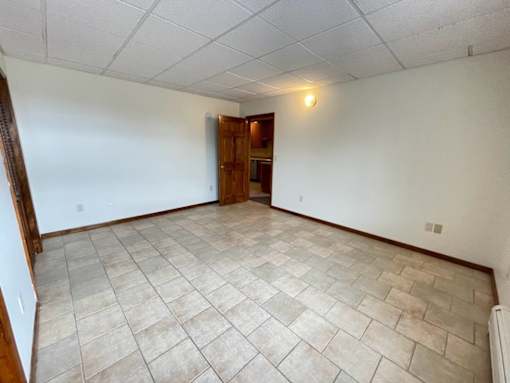 A room with a tiled floor and a wooden door.