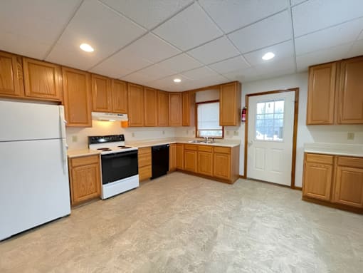A kitchen with wooden cabinets and a white refrigerator.