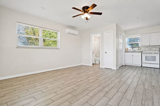 A room with a ceiling fan and wooden flooring.