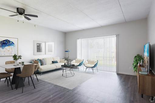 A living room with a white couch, a dining table with chairs, and a television on a wooden stand.