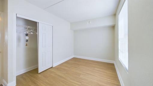 A room with a white door and a wooden floor.