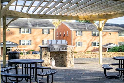A patio with tables and a fireplace in front of a brick building.