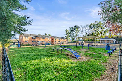A park with a playground and a building in the background.
