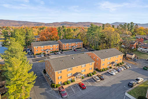 A parking lot in front of a building with a mountain in the background.