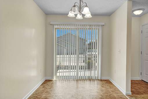 A room with a sliding door leading to a balcony.