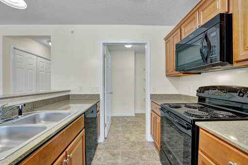 A kitchen with a black microwave above a stove.