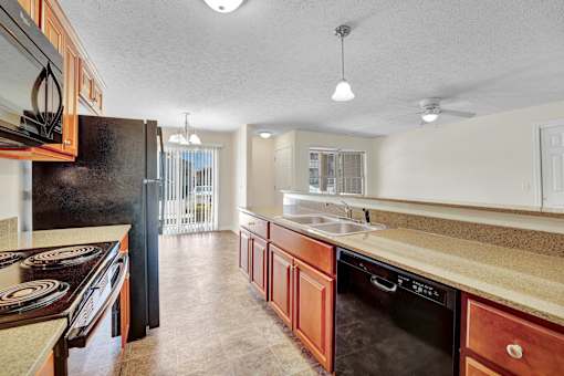 A kitchen with black appliances and wooden cabinets.